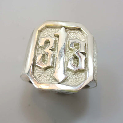 A men's hand made ring in sterling silver. Ring has a 313 logo carved into the ring.