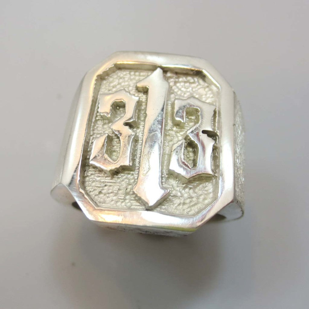 A men's hand made ring in sterling silver. Ring has a 313 logo carved into the ring. 